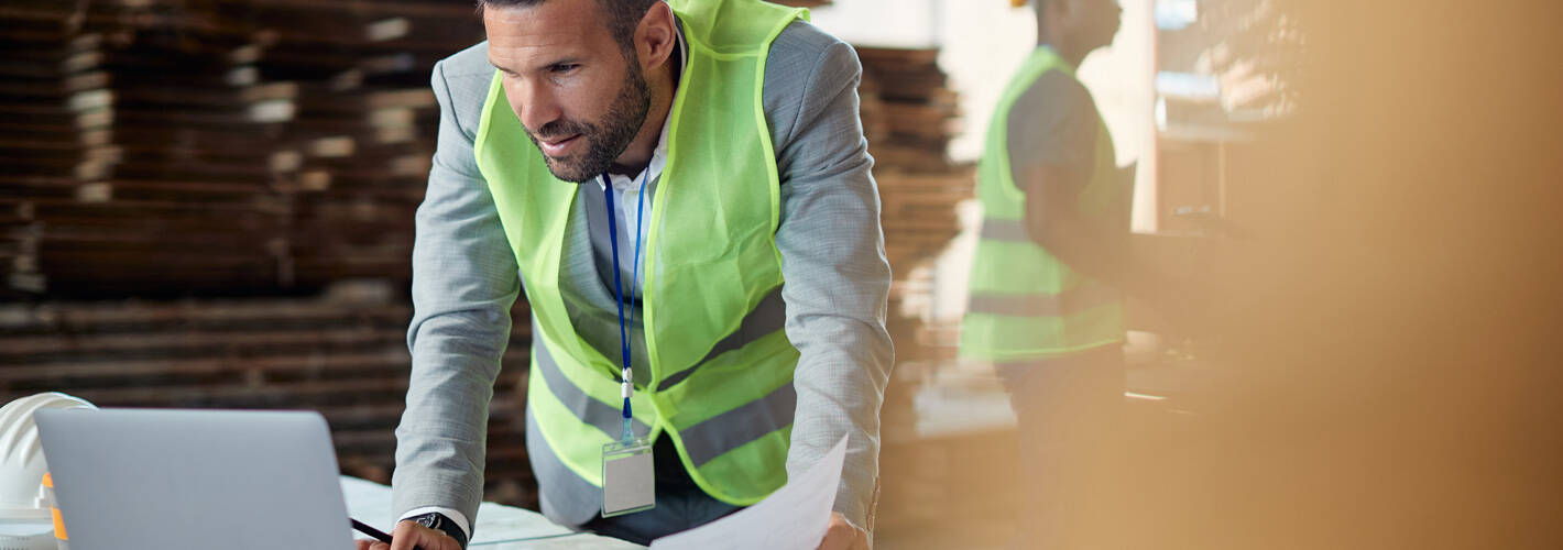 Man looking at a computer on an industrial site